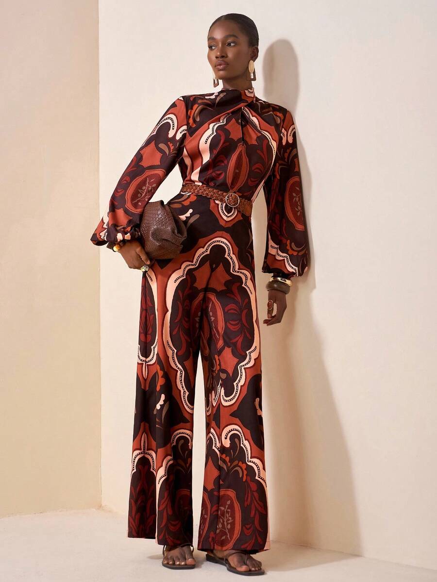 Donna elegante indossa completo coordinato con stampa paisley composto da blusa a collo alto e pantaloni palazzo.