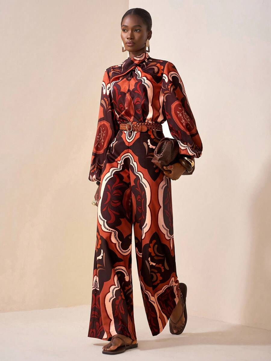  Dettaglio ravvicinato della stampa paisley del completo, focus sui motivi decorativi e sulla texture del tessuto della blusa,