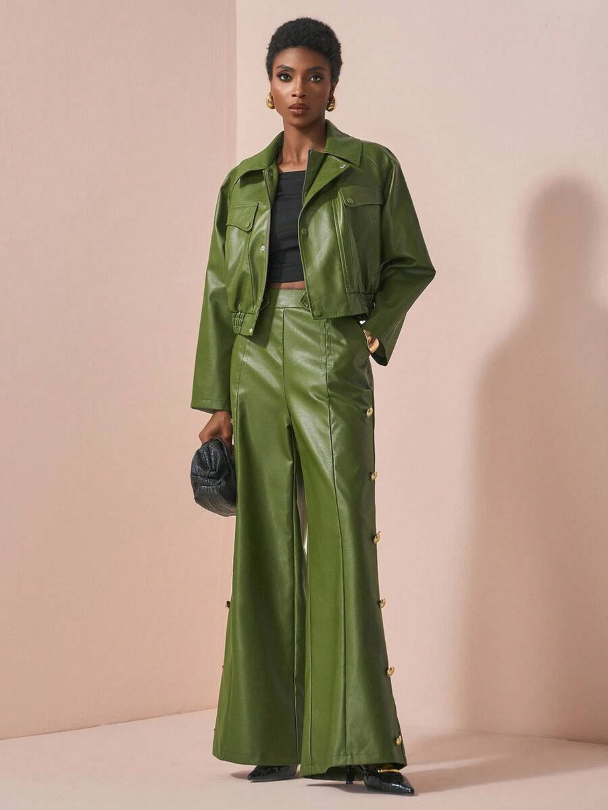 Donna che indossa completo in pelle con giacca strutturata e pantaloni palazzo, look elegante e contemporaneo.