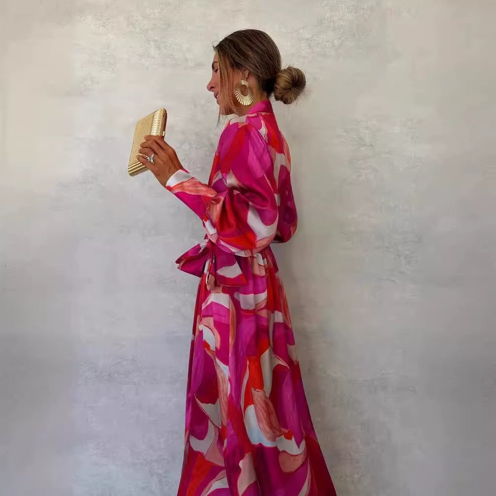 Vestito lungo fucsia stampa astratta indossato per aperitivo estivo con accessori minimal e sandali eleganti
